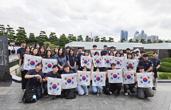 25일 PKNU 학생봉사단 학생들이 부산 남구 유엔기념공원에서 열린 '6·25전쟁 76주년 유엔전몰용사 추모제'에 참여한 뒤 태극기를 들고 평화·보훈의 의미를 되새기고 있다.(사진_국립부경대)