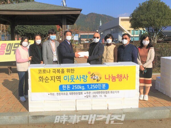 하니움체육관에서 열린 기탁식에 참석한 서봉섭(왼쪽 4번째) 사회복지과장, 박용완(왼쪽 5번째)대한한돈협회 화순지부장 등 협회 관계자가 군청 관계자와 기념 촬영하는 모습.(사진_화순군)