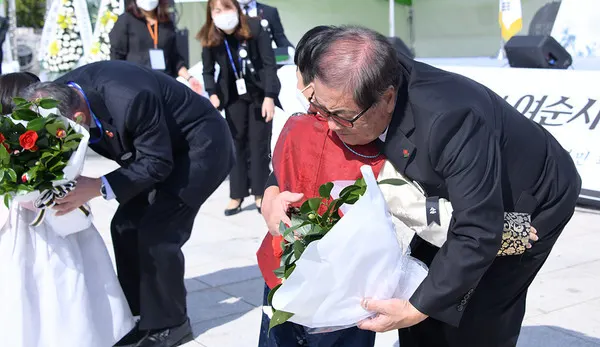 ▲ 윤정근 여순사건 유족회장과 순직 경찰 유족대표에게 남녀 어린아이 2명이 동백꽃을 전달하며 여순사건 희생자와 유족들의 아픔을 위로했다. 이에 화답하듯 두 대표는 동백 배지를 아이들에게 직접 달아주며 화해와 상생, 미래 세대와 더불어 평화와 인권의 희망찬 미래를 만들어 갈 것을 약속했다.