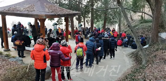 진동산악회 회원들이 용소산 정상에서 해맞이를 하고 나서 떡국을 나누어 먹고 일부는 먹기 위해 줄서 있다. ( 사진:창원시청)