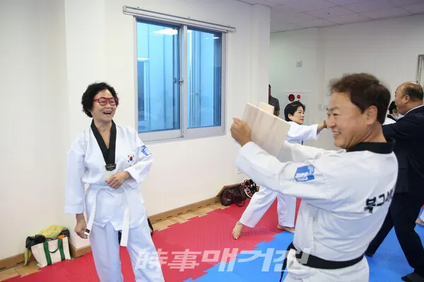 김희석 강사가 잡아준 송판 격파를 마치고 깨진 송판을 보며 활짝 웃어 보이는 심사자 (사진_정연수 기자)