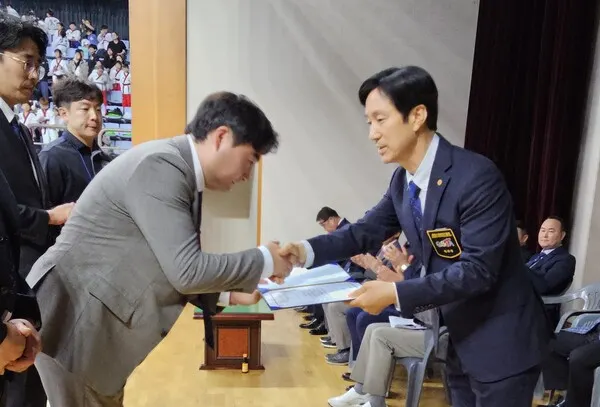 개회식에서 경산시태권도협회 정연준 회장이 우수 임원에서 표창장을 수여하고 있다. 왼쪽은 다힘태권도 윤유경 관장, 오른쪽은 경산시태권도협회 정영준 회장이다.(사진_경산시태권도협회)​