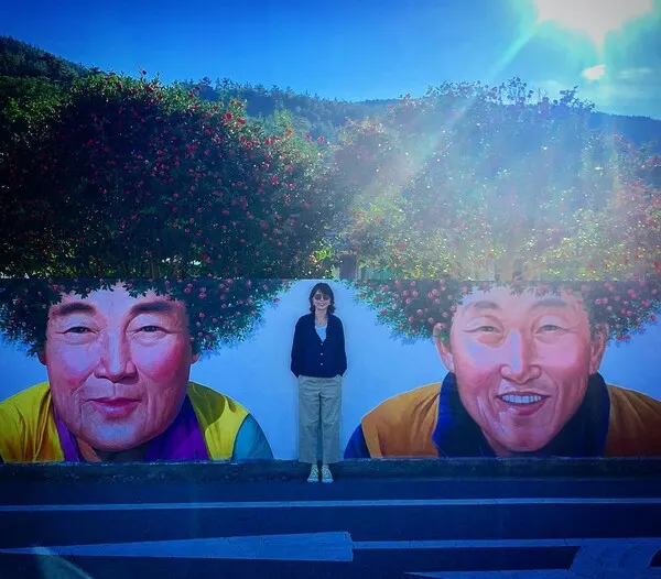 전남 신안군 암태도 기동마을의 벽화는 마을 주민인 손석심 할머니와 문병일 할아버지를 주인공으로, 집 마당에 심어진 애기동백나무를 배경 삼아 그려진 작품으로, 동백꽃이 활짝 핀 봄철에는 마치 '동백꽃 파마'를 한 듯한 모습으로 관광객들의 눈길을 끌고 있다. (사진_박재아)