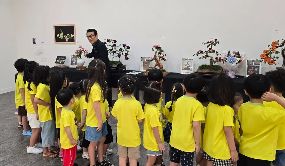 한국예술문화명인 지준학 푸드카빙 작가가 전시회에 방문한 어린이들에게 작품에 대해 설명을 하고있다