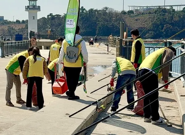23일 가덕도 천성항에서 '자연아 푸르자' 캠페인을 진행하는 가운데 봉사자들이 쓰레기를 수거하고 있다.(사진_신천지자원봉사단 부산서부지부)