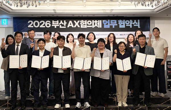 26일 부산AX협의체 참여기관 관계자들이 부산 동래구 호텔농심에서 열린 업무협약식 및 '제1회 AX 확산 포럼'에서 협약서를 들고 기념촬영을 하고 있다.(사진_부산대)