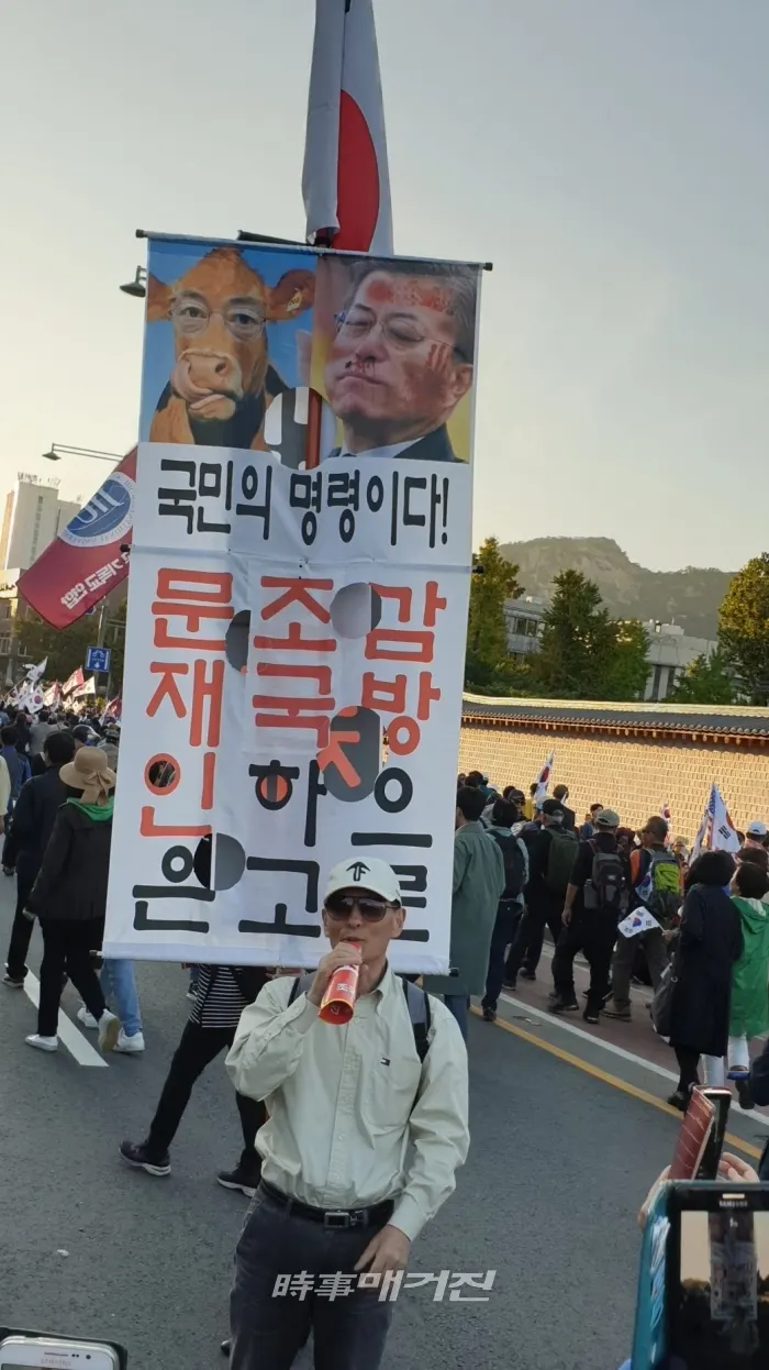 강력한 인상을 남긴 한 참가자가 자신의 소품을 앞세워 행진하고 있다.