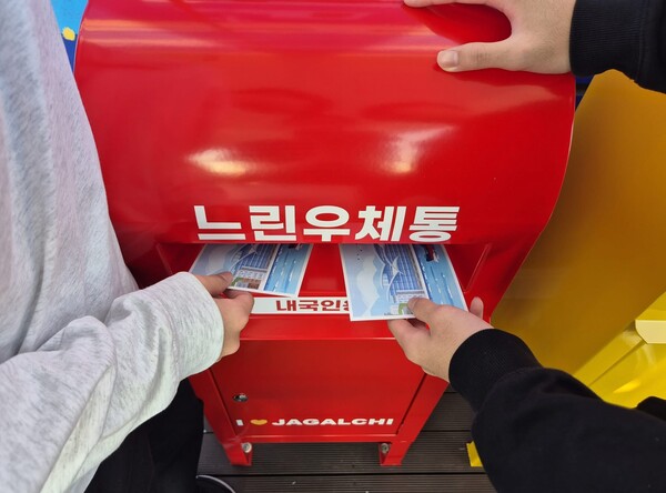 관람객들이 자갈치전망대 '느린우체통'에 엽서를 넣으며 6개월 뒤 전달될 여행의 추억을 남기고 있다.(사진_부산시설공단)