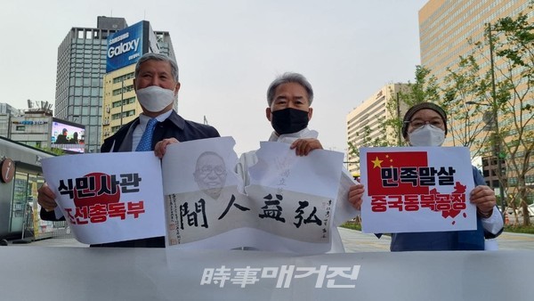최학준 국조전 대표(가운데)가 홍익인간 글씨가 적힌 종이를 찢는 퍼포먼스를 선보이고 있다(사진=김태훈 기자).