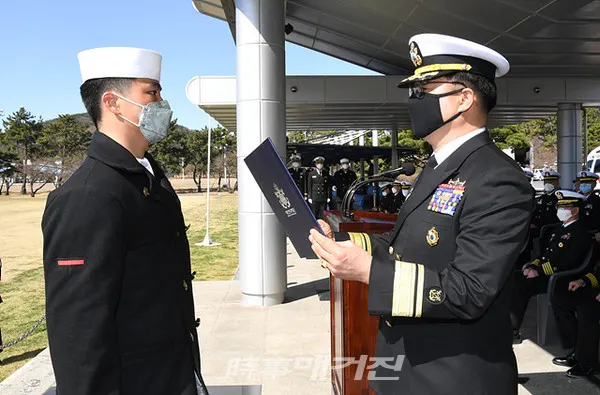해군교육사령부는 20일(금) 코로나19의 지역사회 확산방지와 군내 유입차단을 위해 가족·지인 등 외부인 초청 없이 자체행사로 ‘제664기 해군병 수료식’을 거행했다.사진은 해군교육사령부 연병장에서 실시한 '제664기 해군병 수료식'에서 김현일 해군교육사령관이 이선우 이병에게 교육사령관상을 수여하고 있다. (사진_해군교육사령부)