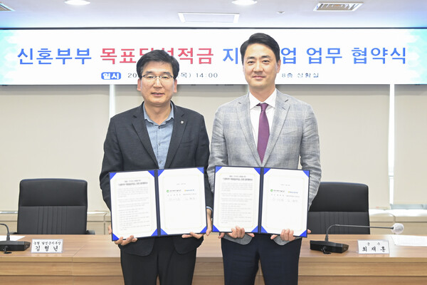 23일 진행된 '신혼부부 목표달성적금 지원사업 업무 협약식'에서 최재훈 달성군수와 김형년 농협 달성군지부장이 협약서를 들어 보이고 있다.(사진_달성군)