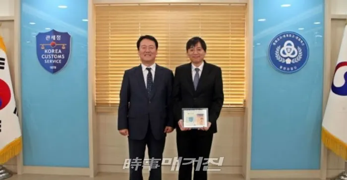 1월의 부산세관인에 선정된 홍성민 관세행정관(오른쪽)과 양승권 부산세관장이 기념촬영을 하고 있다. (사진_부산세관)