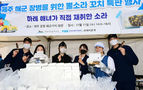 해군 7기동전단이 코로나19 상황 장기화로 인해 어려움을 겪고 있는 지역 어촌계를 돕기 위해 제주산 뿔소라 구매 운동을 추진했다.사진은 제75주년 해군창설일을 맞아 지역경제 활성화를 위해 추진된 뿔소라구이 판매 행사장에서 참가한 해군 장병들과 행사 관계자들이 뿔소라구이를 보여주고 있다.(사진_해군 7기동전단)