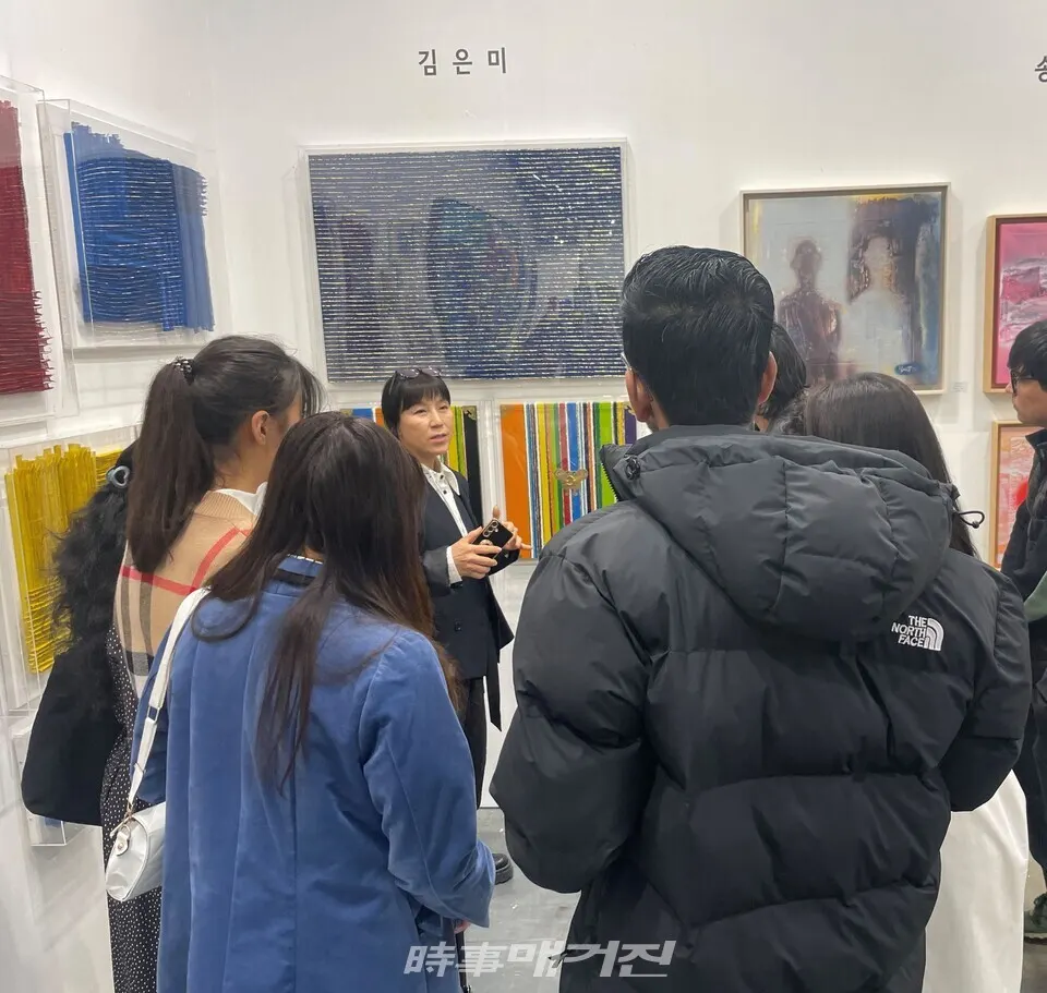 김은미 작가와 김은미 작가의 옻칠 회화 작품 '대지'를 감상하는 갤러리들(사진_ 하명남 기자)