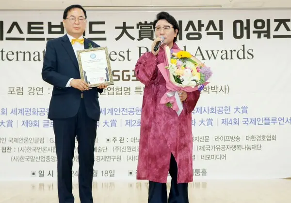 한한국 세계평화작가(우측)가 김명수 대회장으로부터 대상을 수상하고 소감을 밝히고 있다.(사진_한영두 기자)