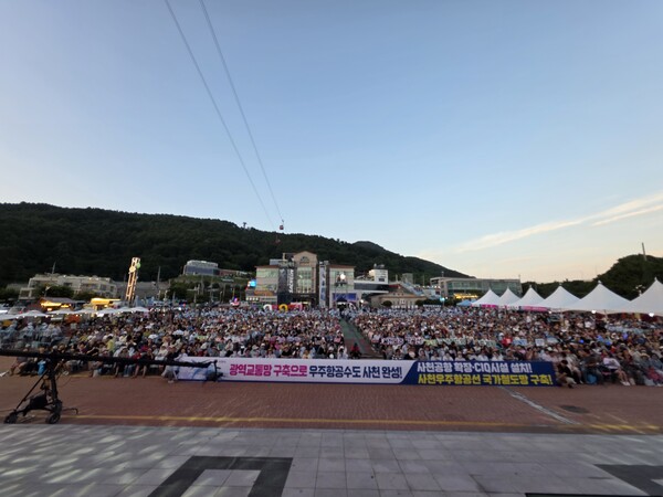 25일 사천시민과 관광객들이 삼천포대교공원에서 열린 '2026 토요상설무대 프러포즈'에 참여해 사천공항 확장과 CIQ 시설 설치, 사천우주항공선의 국가철도망 반영을 촉구하고 있다.(사진_사천시)