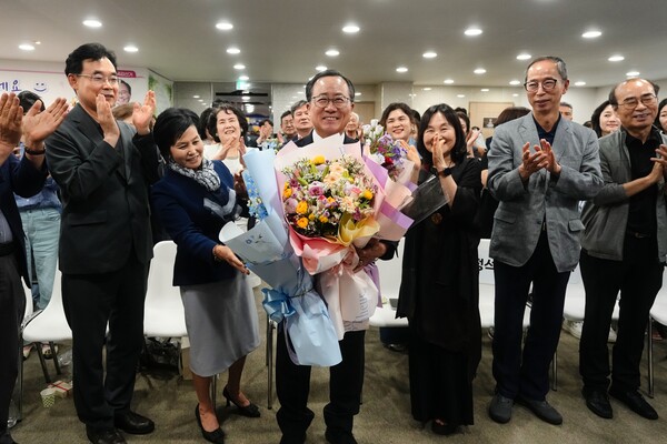 김석준 부산광역시교육감 당선인이 선거 캠프에서 지지자들의 축하를 받으며 꽃다발을 들고 있다.(사진_선거 캠프)