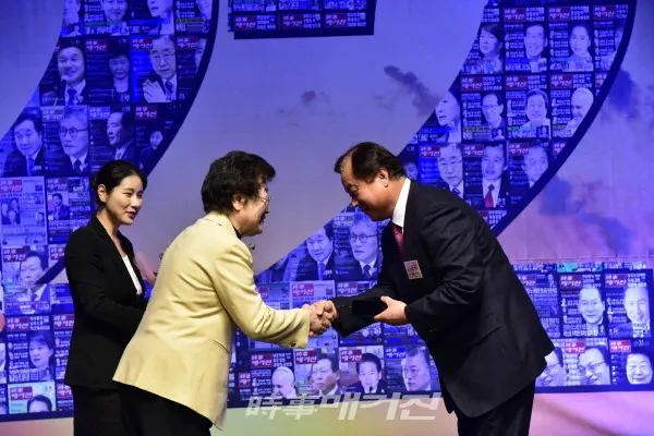안용규 한국체육대학교 총장이 수상 후 장상 대회장과 악수를 하고 있다.