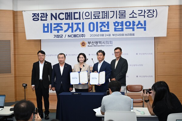 우성빈 기장군수와 강경진 NC메디㈜ 회장 등 관계자들이 24일 부산시의회 브리핑룸에서 의료폐기물 소각시설 비주거지 이전 업무협약을 체결한 뒤 기념촬영을 하고 있다. (사진_기장군)