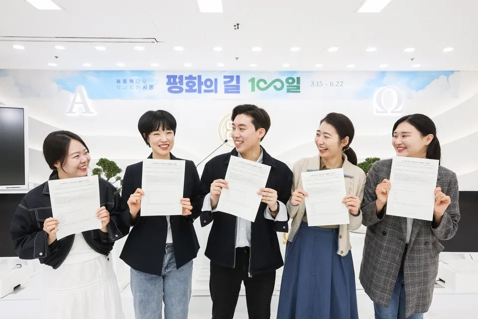 신천지예수교회 성도들이 인 맞음 확인 시험지를 들고 밝게 웃고 있다.(사진_신천지예수교회)