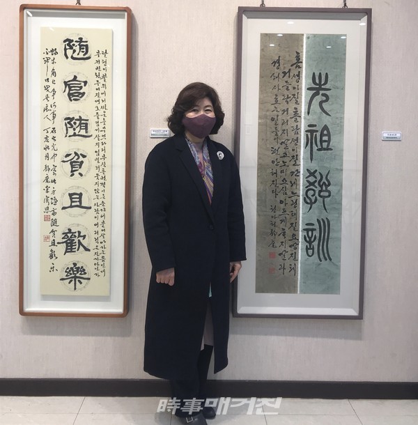 이기은(청아헌)서예작가가 작품앞에서 기념 촬영을 하고 있다.