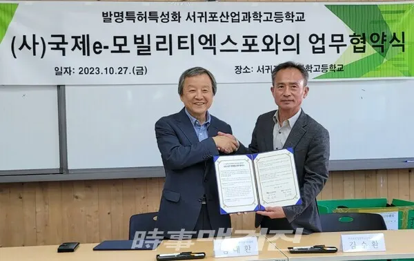 27일 오전 서귀포산과고에서 열린 국제e-모빌리티엑스포와 서귀포산과고 간 업무협약식에서 김대환 IEVE 이사장(왼쪽)과 김수환 서귀포산과고 교장이 협약서에 서명한 후 기념촬영을 하고 있다. (사진_IEVE 제공)
