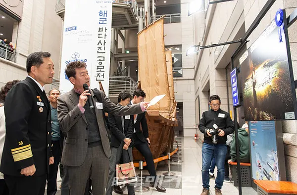 대한민국 해군은 11월 12일부터 17일까지 서울 전쟁기념관 거북선홀에서『해군 바다사진․디자인 공모전 수상작 특별 기획전시회』를 개최한다.사진은 12일 전쟁기념관 거북선홀에서 열린 해군 바다사진ㆍ디자인 공모전 전시회에서 대상작 수상자 김택수씨가 대상작품 '건어장 아침'에 대해 소개하고 있다.(사진_해군)