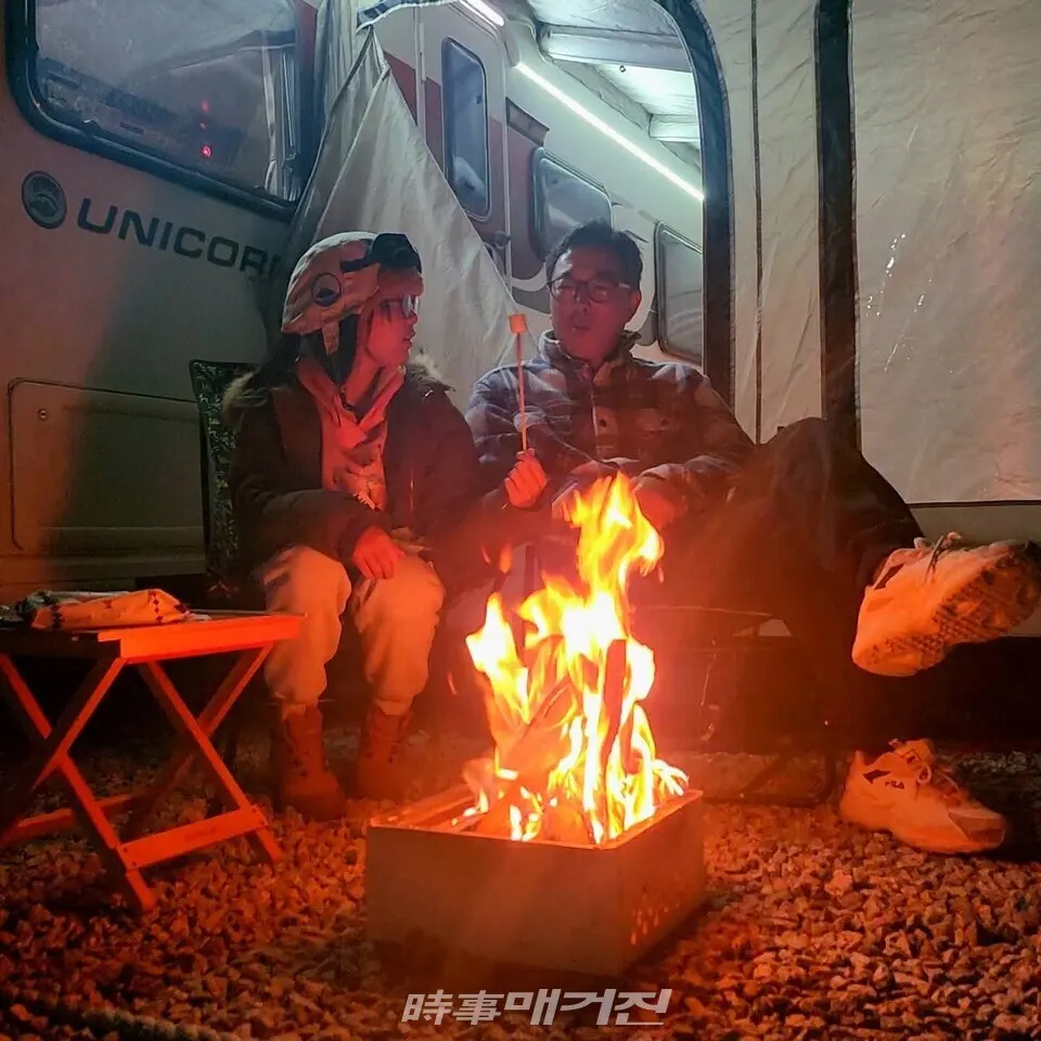 겨울밤 야영장 카라반 앞에서 모닥불 피워놓고 불멍하는 부녀의 모습(사진_조용우)