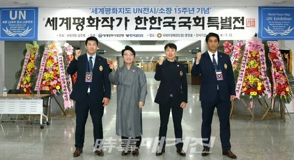 한한국 세계평화작가와 에스티시스템(주) 김재열 대표, 안전요원들이 국회 중앙홀 세계평화지도 전시장에서 파이팅을 외치고 있다.(사진_한영두 기자)