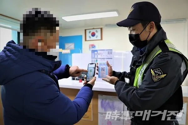 해양경찰관이 어업종사자에게 모바일을 이용한 승선원 변동 신고 방법을 알려주고 있다/사진=목포해양경찰서 제공