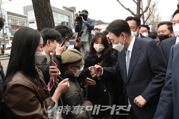 윤석열 대통령 당선인이13일 오찬 후 산책길에 시민과 주먹인사를 나누고 있다(사진/대통령직인수위)