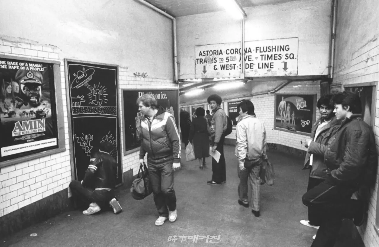 키스 해링(Keith Haring, 1958-1990) © The Keith Haring Foundation, Keith Haring (사진출처=피카프로젝트) 최고운 큐레이터= 지하철역에서 작업하는 해링의 모습. 화폭의 ‘나는 비행접시(Flying Saucer)’는 고도의 힘을 상징하는 비행접시가 사람을 공격하는 모습인데, 기계문명과 발전하는 과학기술이 결국에는 인류를 파괴시킬지도 모른다는 위험성을 경고하고 있다.