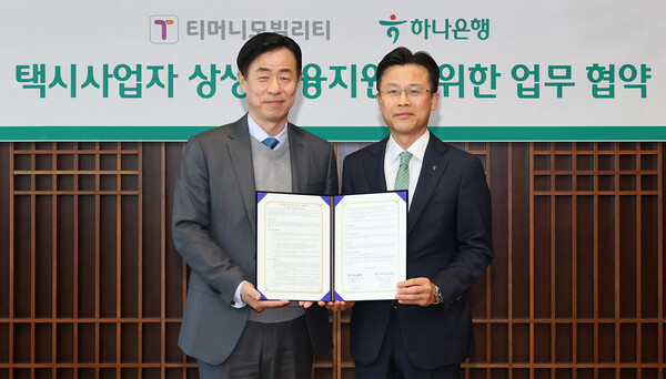 지난 10일 서유석 하나은행 기업그룹 부행장(오른쪽)과 조동욱 티머니모빌리티 대표이사가 서울 을지로 하나은행 본점에서 '택시사업자 상생 금융지원을 위한 업무협약'을 체결한 뒤 협약서를 들고 기념촬영을 하고 있다.(사진_하나은행)