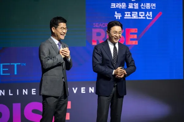 홍석우 운영총괄 상무가 신종면 크라운 로열과 함께 '2021 시크릿 온 라이즈' 온라인 컨벤션 무대 위에서 신규 프로모션을 설명하고 있다
