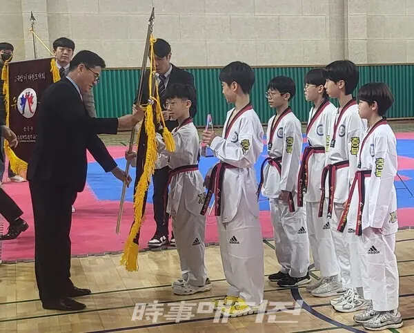 청주시태권도협회 김태훈 회장이 남초부 우승팀 개신초등학교 선수들에게 트로피와 우승기를 전달하고 있다. (사진_이성만 기자)