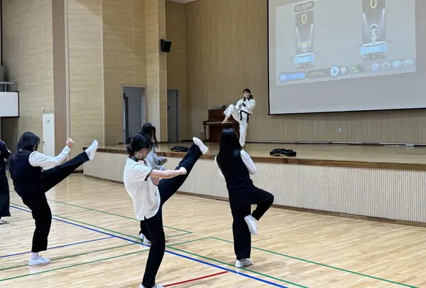 태권도 진로 체험 프로그램에 참가한 학생들이 전자 타격 도구를 활용한 체험 전 발차기를 배우고 있다.(사진_태권도진흥재단)
