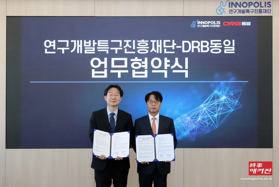 27일 정희권 연구개발특구진흥재단 이사장(왼쪽)과 조현민 DRB동일 대표이사가 지난 대전 사이언스콤플렉스 대덕 커넥트 라운지에서 제조산업 혁신과 딥테크 기술 사업화를 위한 업무협약을 체결한 뒤 협약서를 들고 기념촬영을 하고 있다.(사진_DRB동일)