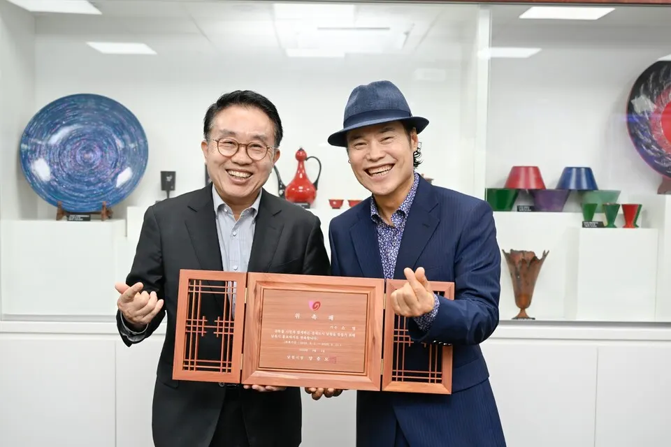 양충모 남원시장(왼쪽)이 가수 소명(오른쪽)홍보대사 위촉패를 전달하고 기념사진을 촬영하고 있다