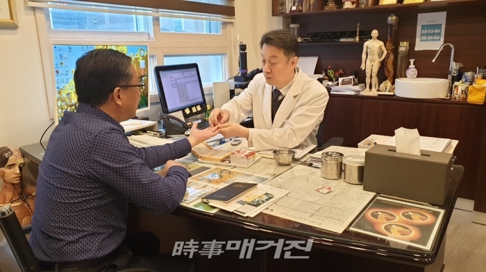 ▲ 소우주 요양병원의 조기용 원장과 강현섭 현장취재기자의 모습. 혈액 상태를 체크하여 적혈구, 백혈구 및 혈소판이나 기타 혈액요소들의 활동상태를 고배율 현미경을 통해 관찰한다.