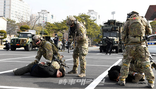 해군 진해기지사령부(사령관 준장 강성희)는 2월 11일(화) 오전 진해 해군회관 인근에서 군(軍)경(警) 병력 100여 명이 참가한 가운데 합동 대테러 훈련을 실시했다.사진은 11일(화) 실시된 군경 합동 대테러 훈련에서 해군 특수전전단 소속 장병들이 가상의 테러범을 제압하고 있다.(사진_해군 진해기지사령부)