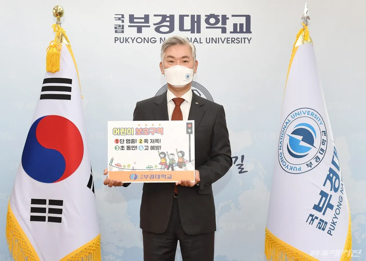 장영수 총장이 ‘어린이 보호구역 1단 멈춤! 2쪽 저쪽! 3초 동안! 4고 예방!’ 팻말을 들고 기념촬영하고 있다.(사진_부경대학교)
