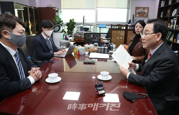 주호영(오른쪽) 국민의힘 원내대표가 26일 국회 의원회관 사무실에서 최재성 청와대 정무수석에게 '다시 대통령에게 드리는 10가지 질문'이라고 써진 서신을 넣은 서류봉투를 전달하고 있다.(사진_공동취재단)