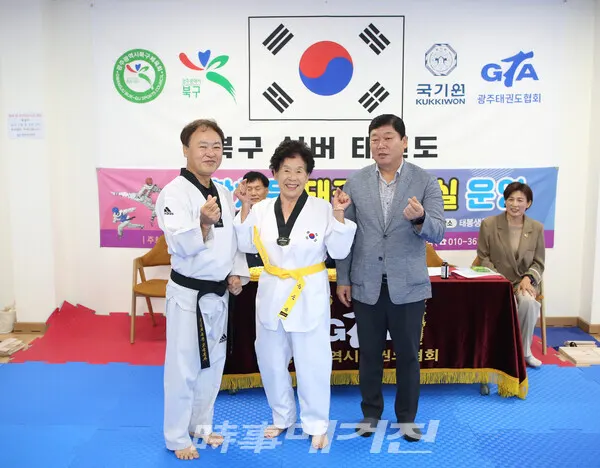 최고령 송순금(89세)어르신이 심사에 합격하고 북구체육회 정희환 회장으로부터 노란띠를 수여 받고 김희석 강사와 함께 (사진_정연수 기자)