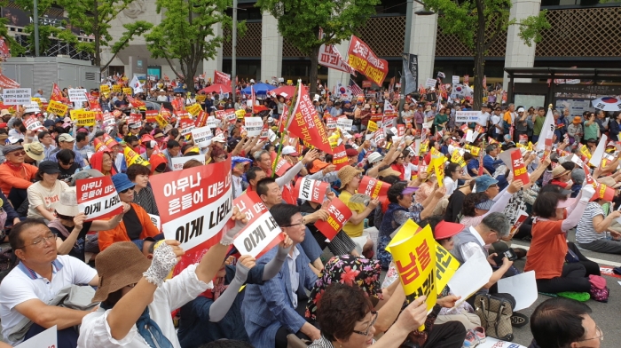 광화문광장에 앉아 연사들의 발언에 연호하는 당원 등 참석자들(사진_시사매거진)