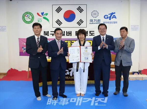 문인 북구청장으로부터 2단 단증을 수여 받은 윤금자 어르신 (사진_정연수 기자)