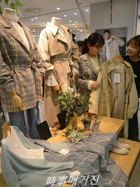 올 봄 여성들의 패션은 깔끔하고 정돈된 스타일의 체크무늬 재킷과 트렌치코트가 필수 아우터로 각광 받고 있다.. 롯데백화점 부산본점 7층 영패션 브랜드 오버톤에서는 봄을 맞아 신상 체크무늬 재킷과 트렌치코트를 고객이 살펴보고 있다. (사진_롯데백화점 부산본점)